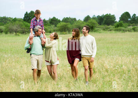 Familie gehen zusammen durch Feld Stockfoto