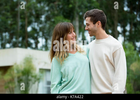 Junges Paar an jedem anderen im Freien lächeln Stockfoto