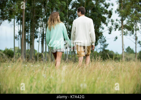 Junges Paar Walking und halten sich an den Händen im freien, Rückansicht Stockfoto