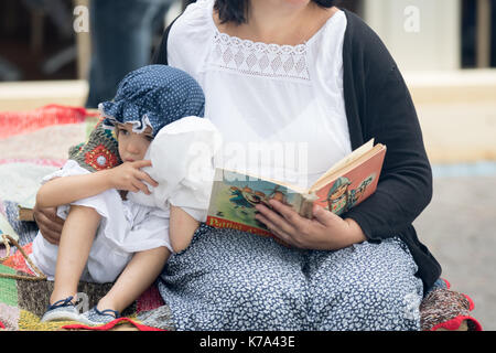 Asti, Italien - September 10, 2017: Mama liest ein Buch zu ihrem kleinen Sohn Stockfoto
