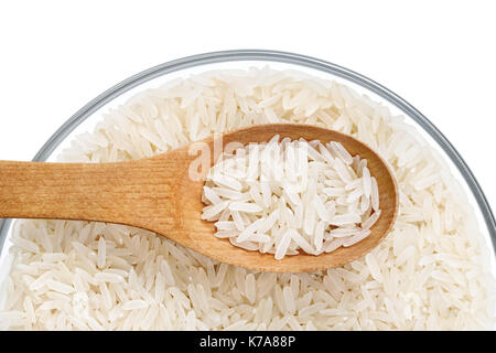 Gesundes Essen. Parboiled Reis und Holzlöffel in Glasschale auf weißem Hintergrund. Close Up. Ansicht von oben. Hochauflösende Produkt. Stockfoto