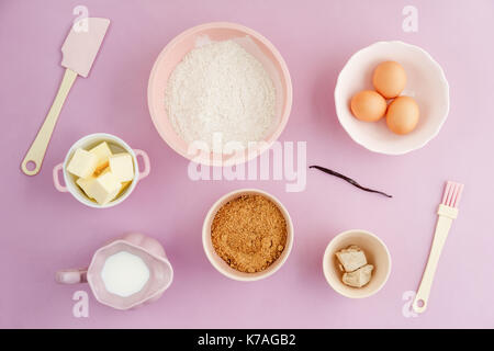 Flatlay Sammlung von Tools und Zutaten für zu Hause Backen auf rosa Hintergrund Schuß von oben Stockfoto