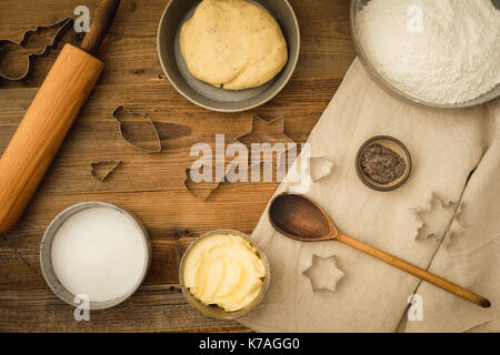 Flatlay Sammlung von Tools und Zutaten zum Backen vegane Weihnachtsplätzchen mit Margarine und Chia Samen als Ei Ersatz auf einem dunklen Holztisch Stockfoto