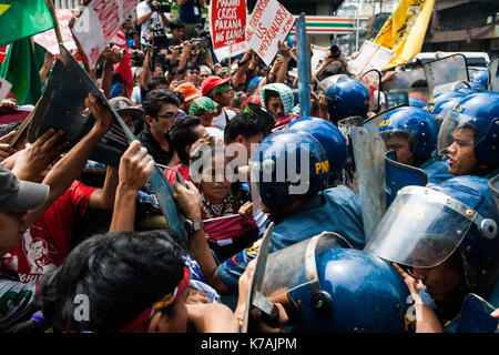 Manila, Philippinen. 15 Sep, 2017. Die Demonstranten werden gesehen Scuffling mit Polizisten, als Sie schieben Sie ihren Weg in die US-Botschaft zu öffnen. Bestehend aus vor allem der indigenen Bevölkerung von Mindanao, Philippinen (die zweitgrößte Insel) hunderte Demonstranten marschierten in Richtung der US-Botschaft gegen die politischen Ideen des Präsidenten der Vereinigten Staaten von Amerika, Donald Trump und den Philippinen Präsident Rodrigo Duterte in Roxas Boulevard zu protestieren vor der Masse der Polizeibeamten in Kalaw Avenue blockiert wird, ein paar hundert Meter von der US-Botschaft. Am 15. September 2017 in Manila, Philadelphia Stockfoto