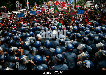 Manila, Philippinen. 15 Sep, 2017. Die Demonstranten werden gesehen Scuffling mit Polizisten, als Sie schieben Sie ihren Weg in die US-Botschaft zu öffnen. Bestehend aus vor allem der indigenen Bevölkerung von Mindanao, Philippinen (die zweitgrößte Insel) hunderte Demonstranten marschierten in Richtung der US-Botschaft gegen die politischen Ideen des Präsidenten der Vereinigten Staaten von Amerika, Donald Trump und den Philippinen Präsident Rodrigo Duterte in Roxas Boulevard zu protestieren vor der Masse der Polizeibeamten in Kalaw Avenue blockiert wird, ein paar hundert Meter von der US-Botschaft. Am 15. September 2017 in Manila, Philadelphia Stockfoto