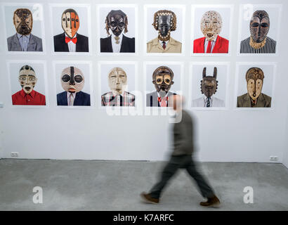 Schwerin, Deutschland. 15 Sep, 2017. Ein Mann übergibt die Foto-Serie "Tipo Passe' des Künstlers Edson Chagas an der Art Association in Schwerin, Deutschland, 15. September 2017. 'Madgermanes' bezieht sich Arbeitnehmer aus Mosambik, lebte und arbeitete in der ehemaligen DDR zwischen 1979 und 1991 unter Vertrag zu nehmen. Die Ausstellung läuft vom 17. September bis 28. November 2017. Foto: Jens Büttner/dpa/Alamy leben Nachrichten Stockfoto