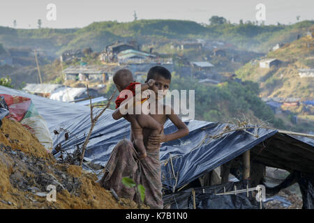 September 15, 2017 Ukhiya, Bangladesch. 15 Sep, 2017. Ein Rohingya Junge mit seinem Bruder steht nah an ihrem provisorischen Zelt am Balukhali camp in Ukhiya, Bangladesch. Viele der Rohingya auf der Flucht vor der Gewalt in Myanmar hatte mit dem Schiff reiste Zuflucht im benachbarten Bangladesch zu finden. Nach Angaben der Vereinten Nationen mehr als 300 tausend Rohingya-flüchtlinge Myanmar von Gewalt in den letzten Wochen geflohen, die meisten versuchen, die Grenze zu überqueren und Bangladesch zu erreichen. Credit: K M Asad/ZUMA Draht/Alamy leben Nachrichten Stockfoto