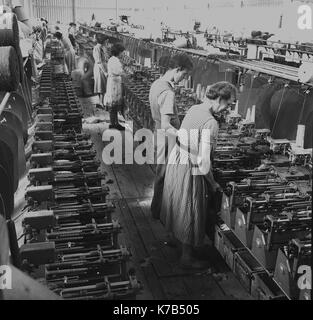 1950, historische, Irish Weavers, weibliche Arbeitnehmer auf Holzdielen mit mechanisierten Bettwäsche Webstühle stehend, Nordirland. Stockfoto