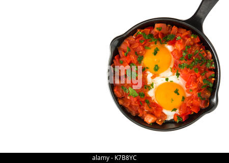 Shakshuka in Eisen Braten auf weißem Hintergrund pan. Typisches Essen in Israel. Stockfoto