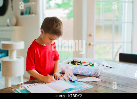 Cute boy Zeichnung auf Papier zu Hause Stockfoto