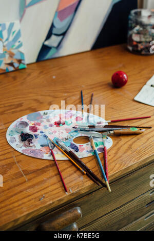Close-up Pinsel mit unordentlichen bunte Palette auf hölzernen Tisch Stockfoto