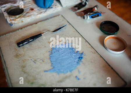 Close-up Blau aquarell Malen durch Abstreifer auf Fach am Tisch in der Werkstatt Stockfoto