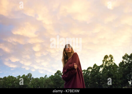 Junge Frau draußen in der Dämmerung, Porträt Stockfoto
