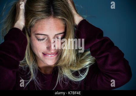 Verärgert junge Frau die Hand und beißen Lippen Stockfoto