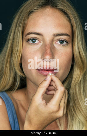 Junge Frau Vorbereitung Pille zu nehmen Stockfoto