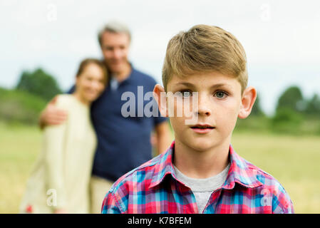 Junge mit Eltern im Hintergrund, Porträt Stockfoto