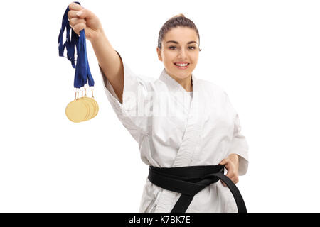 Karate Mädchen mit Goldmedaillen und lächelnd auf weißem Hintergrund Stockfoto