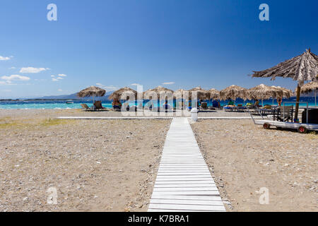 Holz- Pfad durch Sandstrand, Weg, um die Tropical Bar mit Sonnenschirm und Liegestühlen. Stockfoto