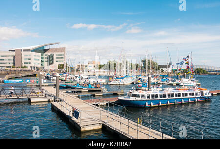 Die Cardiff Bay, Mermaid Quay, mit Boote im Hafen und der Norwegischen Kirche und der Arzt, der Erfahrung Gebäude im Hintergrund. Stockfoto