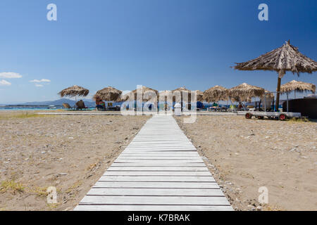 Holz- Pfad durch Sandstrand, Weg, um die Tropical Bar mit Sonnenschirm und Liegestühlen. Stockfoto