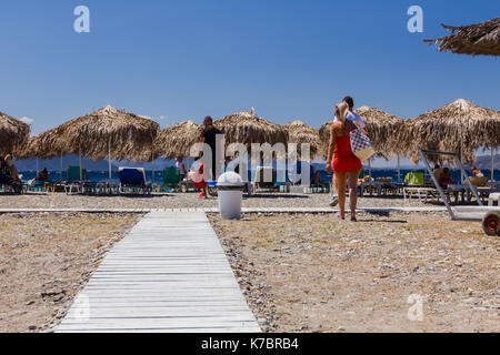 Holz- Pfad durch Sandstrand, Weg, um die Tropical Bar mit Sonnenschirm und Liegestühlen. Stockfoto