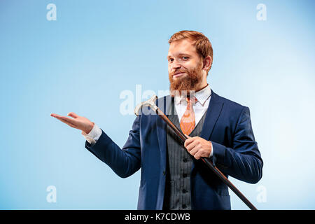 Die barded Mann im Anzug holding Zuckerrohr. Stockfoto