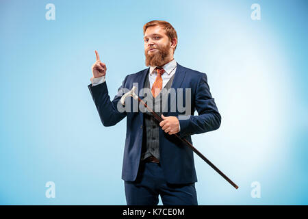 Die barded Mann im Anzug holding Zuckerrohr. Stockfoto