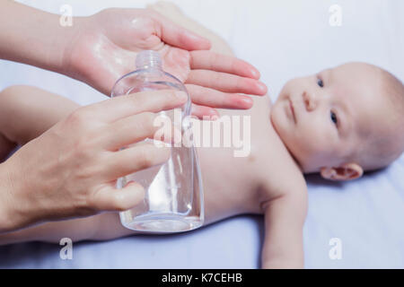 Vor kurzem gereinigt Baby bereit für Öl. Mutter mit Flasche in der hand Stockfoto