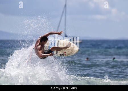 Junger Surfer trotzt der Schwerkraft beim Wellenreiten am Wellenbrecher in Lahaina auf Maui. Stockfoto