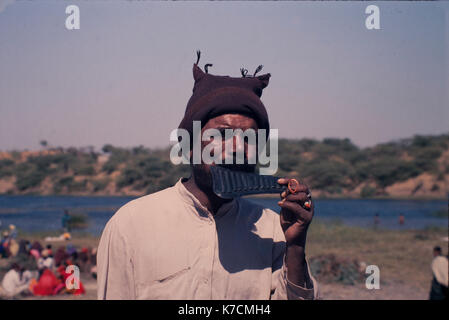 Mann spielt ein Spielzeug Instrument auf der Messe Stockfoto
