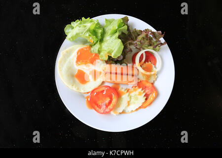 Spiegelei und Wurst mit frischem Gemüse in Weiß Teller auf Lebensmittel Tabelle. Stockfoto