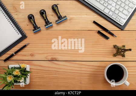 Büro Schreibtisch Tisch mit Notizbuch, Stift, Tasse Kaffee und Blume. Ansicht von oben mit der Kopie Raum (selektive Fokus) Stockfoto