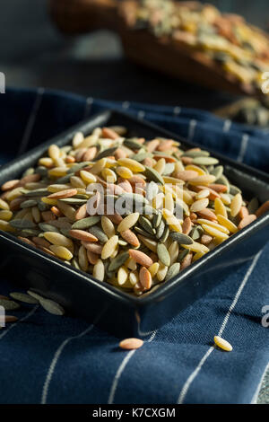 Trockene organische Tricolor Orzo Pasta in eine Schüssel geben. Stockfoto