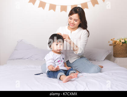 Glücklich liebende Familie. Mutter und Kind Mädchen haben Spaß auf dem Bett. Stockfoto