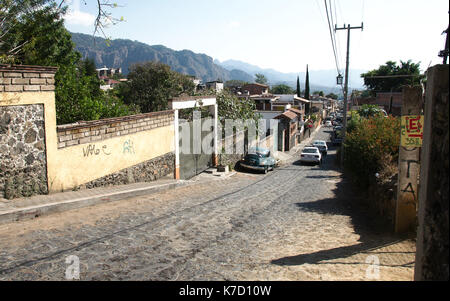 Tepoztlan, Morelos, Mexiko - 2013: eine Straße im historischen Zentrum der Stadt, mit der Pirámide de Berg im Hintergrund. Stockfoto