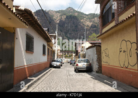 Tepoztlan, Morelos, Mexiko - 2013: eine Straße im historischen Zentrum der Stadt, mit der Pirámide de Berg im Hintergrund. Stockfoto