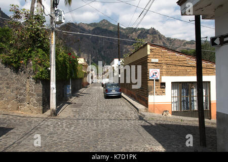 Tepoztlan, Morelos, Mexiko - 2013: eine Straße im historischen Zentrum der Stadt, mit der Pirámide de Berg im Hintergrund. Stockfoto