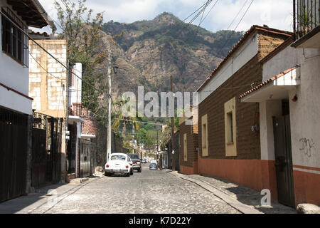 Tepoztlan, Morelos, Mexiko - 2013: eine Straße im historischen Zentrum der Stadt, mit der Pirámide de Berg im Hintergrund. Stockfoto