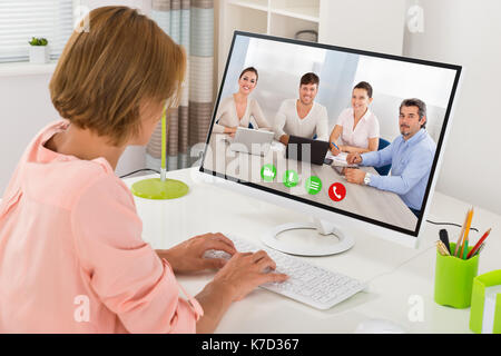 Junge Frau Videokonferenzen mit Kollegen auf dem Computer am Schreibtisch Stockfoto