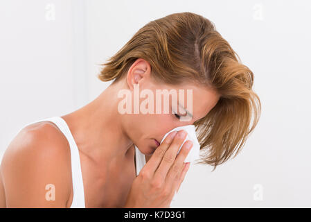 Porträt der jungen Frau Blasen Nase in Seidenpapier Stockfoto