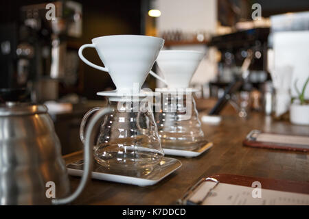 Nahaufnahme der Kaffeefilter Tassen auf Glas Container im Coffee Shop Stockfoto