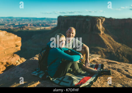 Portrait von Wandern Paar sitzt auf dem Berg gegen Felsformation im Canyonlands National Park Stockfoto