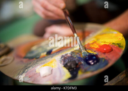 Nahaufnahme der Mann mit Aquarellfarbe Palette in der Werkstatt Stockfoto