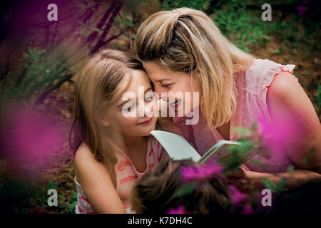 Hohe Betrachtungswinkel der glücklichen Mutter und Tochter beim Lesen Buch genießen. Stockfoto