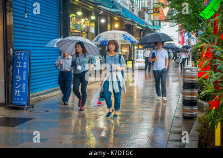 Tokio, Japan, 28. Juni - 2017: unbekannte Menschen zu Fuß unter dem Regen in den Bürgersteig mit Sonnenschirme in Jimbocho Bezirk in Tokio Stockfoto