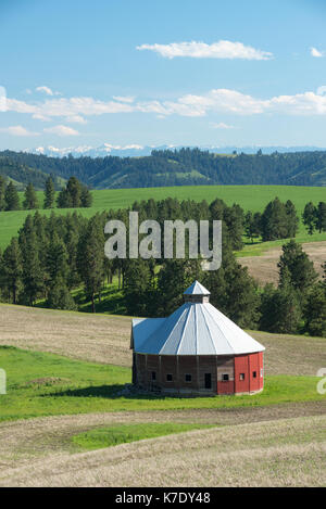 Runde Scheune auf einem Bauernhof in der Nähe von Flora, Oregon, mit der Wallowa Mountains im Hintergrund. Stockfoto