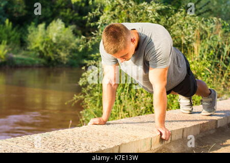 Mann, die Push-ups durch den Fluss Stockfoto