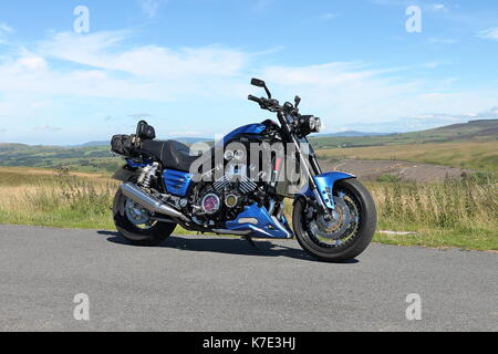 Angepasste Yamaha vmx 1200 cc Motorrad auch als Vmax auf einer Landstraße in Wales an einem sonnigen Tag mit blauen Himmel und Hügel geparkt Stockfoto