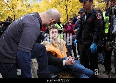 FDNY Sanitäter neigen dazu, einem Schlaf- und kranken Besetzt die Wall Street Demonstrant im Zuccotti Park, New York am 16. November 2011. Nach einem erzwungenen Vertreibung aus der Stockfoto