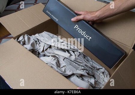 Auslieferung auspacken. Hände öffnen einen Versandkarton Stockfoto